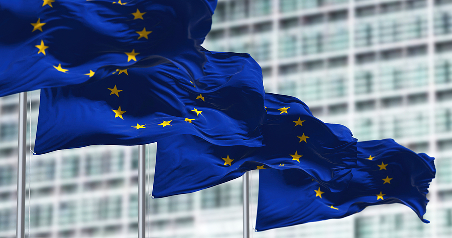 European flags waving in the wind in front of the European Parliament building in Brussels